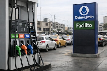 Primer plano de surtidores de gasolina, GLP, GNV y diésel en una estación de servicio en Lima, Perú, con un cartel de Osinergmin y Facilito. Autos en fila al fondo.