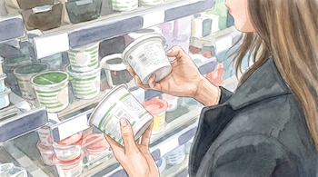 Una persona con cabello largo examina dos envases de productos en una góndola de supermercado con múltiples recipientes.
