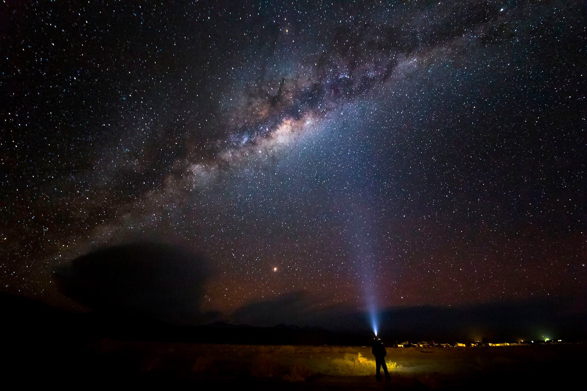 Una persona proyecta un haz de luz hacia la Vía Láctea en el cielo nocturno del desierto de Atacama en Chile. (Pexels)