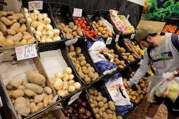 Un cliente compra patatas en una frutería, en Ronda, Andalucía, España (Jon Nazca / Reuters)