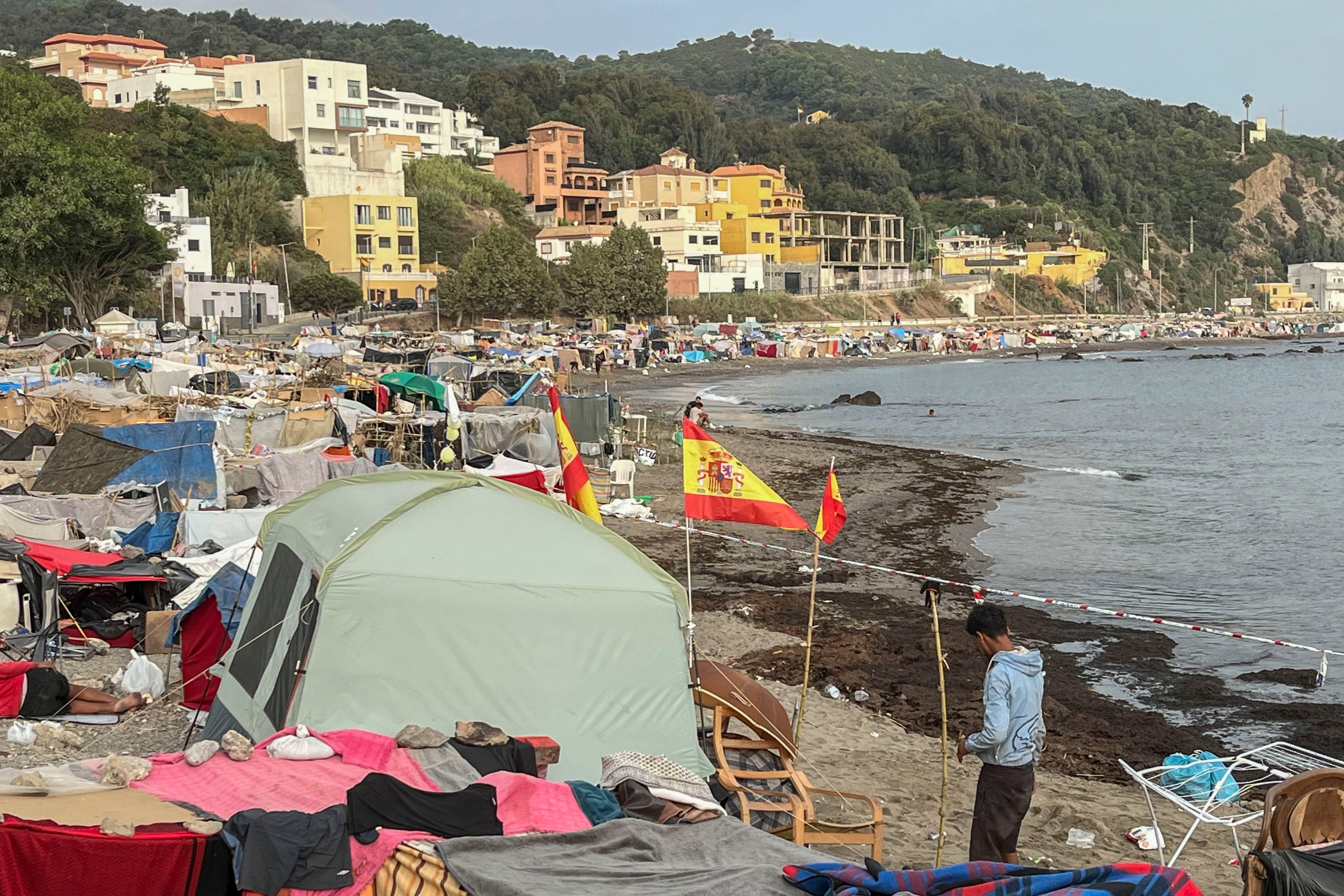 Vista de las tiendas de campaña y construcciones improvisadas por migrantes en la playa del Trampolín en Ceuta. (EFE/ Reduan)