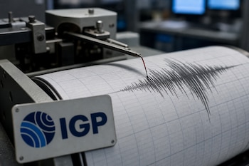 Un sismógrafo analógico con una aguja marcando papel milimetrado y una placa con el logotipo del Instituto Geofísico del Perú.