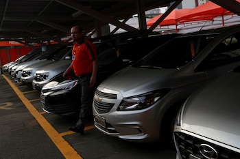 Un hombre camina entre automóviles estacionados en el servicio de arriendo de vehículos Movida especializado en compañías de viajes por aplicaciones en Sao Caetano do Sul (REUTERS/Amanda Perobelli/Archivo)