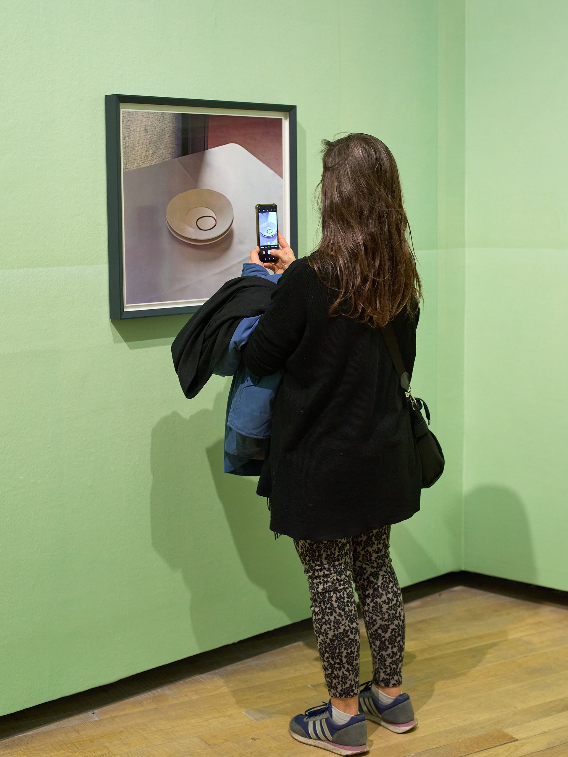 Una visitante toma una fotografía con su teléfono móvil a una obra de la exposición de Thomas Demand en la Fundación Proa.