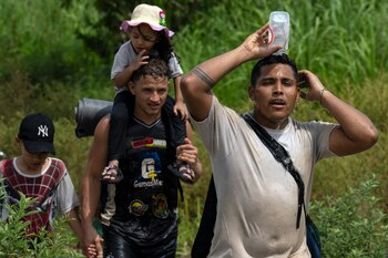 Un migrante se refresca bajo