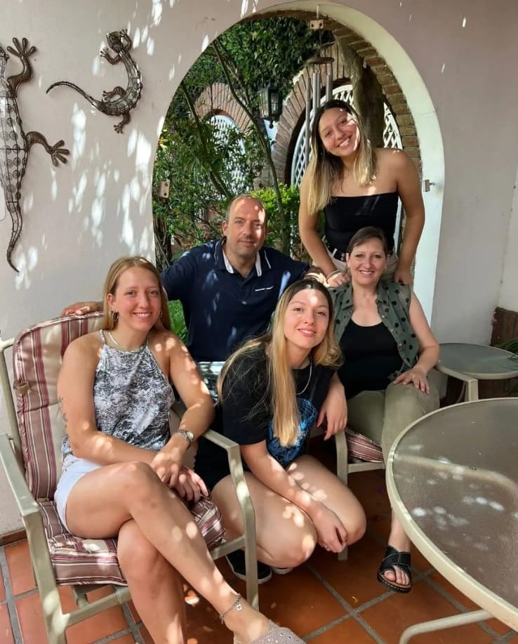 Fernando Confessore y Paula Franco posan en un patio junto a sus tres hijas, Julieta, Candela y Jimena