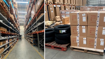 Interior de un gran almacén con estanterías altas que contienen cajas de cartón y bultos, y neumáticos de vehículos apilados sobre paletas de madera
