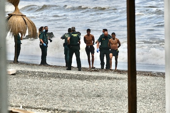 Guardias Civiles arrestan a migrantes marroquíes en la playa del Tarajal, en Ceuta (Antonio Sempere / Europa Press)