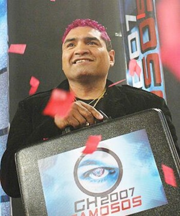 Jorge Castro sostiene un maletín negro con el logotipo de GH 2007 Famosos mientras cae confeti rojo