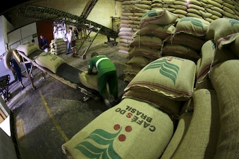 Imagen de archivo de un trabajador cargando un saco de café de 60 kilogramos en una cinta transportadora en una bodega en Santos, Brasil (REUTERS/Paulo Whitaker)
