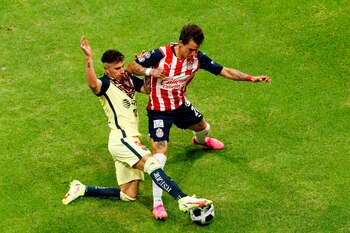 El jugador de América Jorge Sánchez (i) disputa el balón con Cristian Calderón (d) de Chivas hoy, durante un partido del Torneo Apertura del fútbol mexicano en el Estadio Azteca de la Ciudad de México (México). EFE/José Méndez