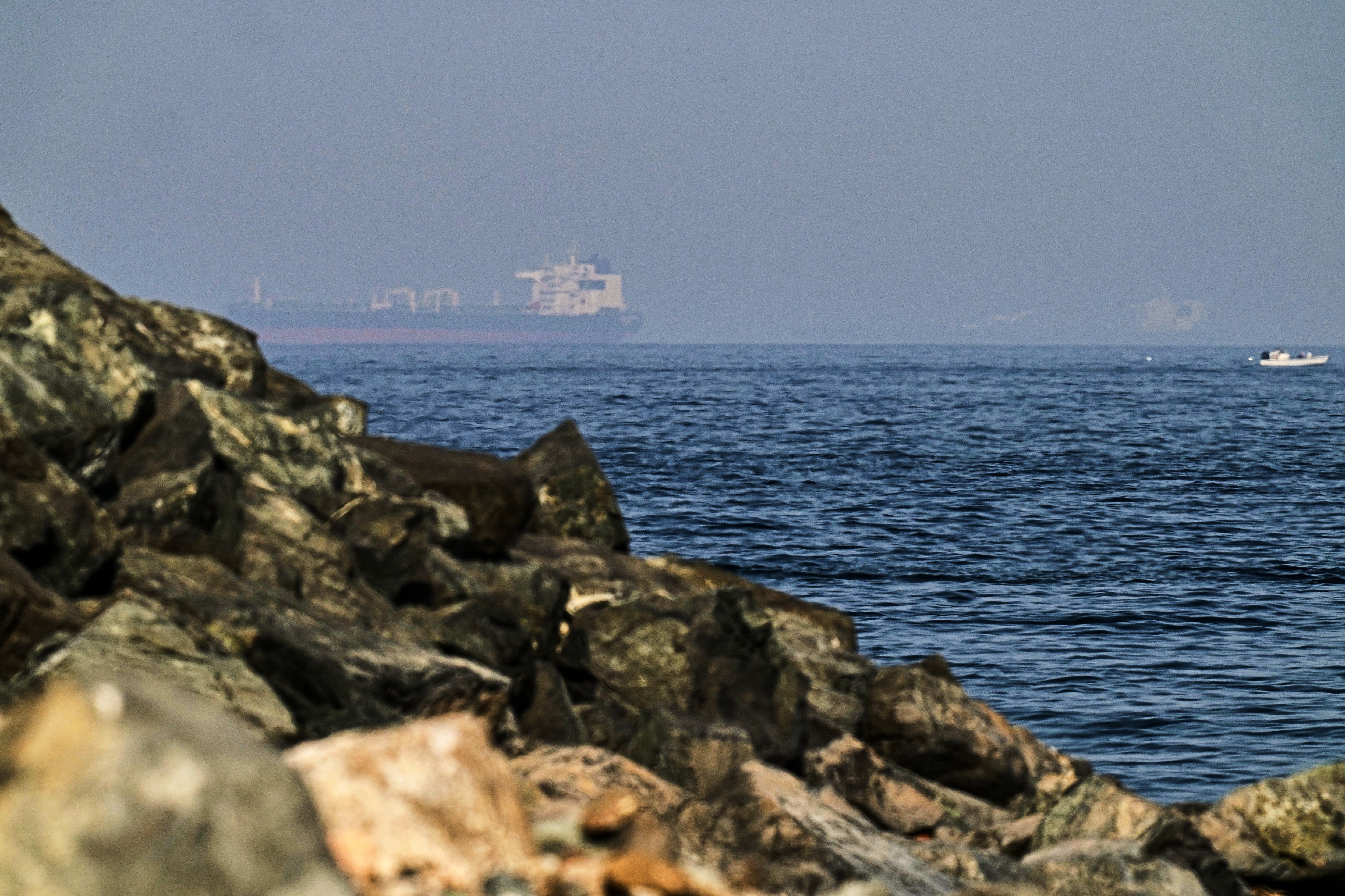 Buques de carga navegan por el Golfo de Omán, cerca del Estrecho de Ormuz, cuyo bloqueo impuesto por Irán retiene aproximadamente una quinta parte del petróleo y el gas natural licuado que se comercializa en el mundo. (AP/Fatima Shbair)