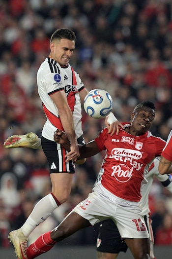 River Plate's Colombian forward #19 Rafael Santos Borre heads the ball past Santa Fe's defender #13 Helibelton Palacios during the second leg of the Copa Sudamericana round of 16 football match between Argentina's River Plate and Colombia's Independiente Santa Fe at Mas Monumental stadium in Buenos Aires on August 26, 2026. (Photo by JUAN MABROMATA / AFP)