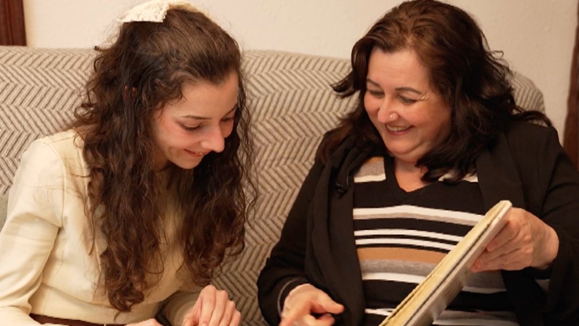 Noelia Castillo Ramos, la joven parapléjica que recibirá la eutanasia, viendo un álbum de fotos junto a su madre, Yolanda Ramos (Antena 3)