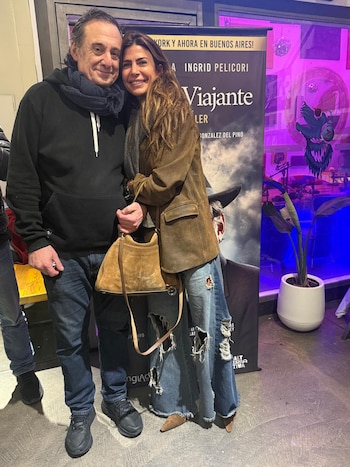 Alejandro Awada y Juliana Awada sonríen y se abrazan frente a un cartel de la obra "La Muerte de un Viajante" en un evento nocturno