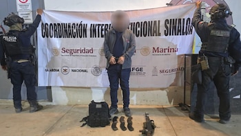 Con un rifle AK-47 y