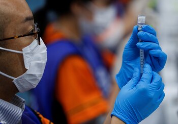 Un trabajador sanitario llena una jeringa con una dosis de la vacuna contra la enfermedad del coronavirus (COVID-19) de Pfizer-BioNTech en el Tokyo Dome, Japón, el 16 de agosto de 2021. REUTERS/Issei Kato