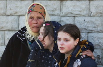 La abuela con sus nietas en una aldea cercana a Kharkiv que estuvo ocupada por los rusos durante casi un mes. En estos pueblos se suceden las denuncias sobre personas que habrían señalado a los soldados rusos la ubicación de los centros de acopio de alimentos. REUTERS/Ricardo Moraes