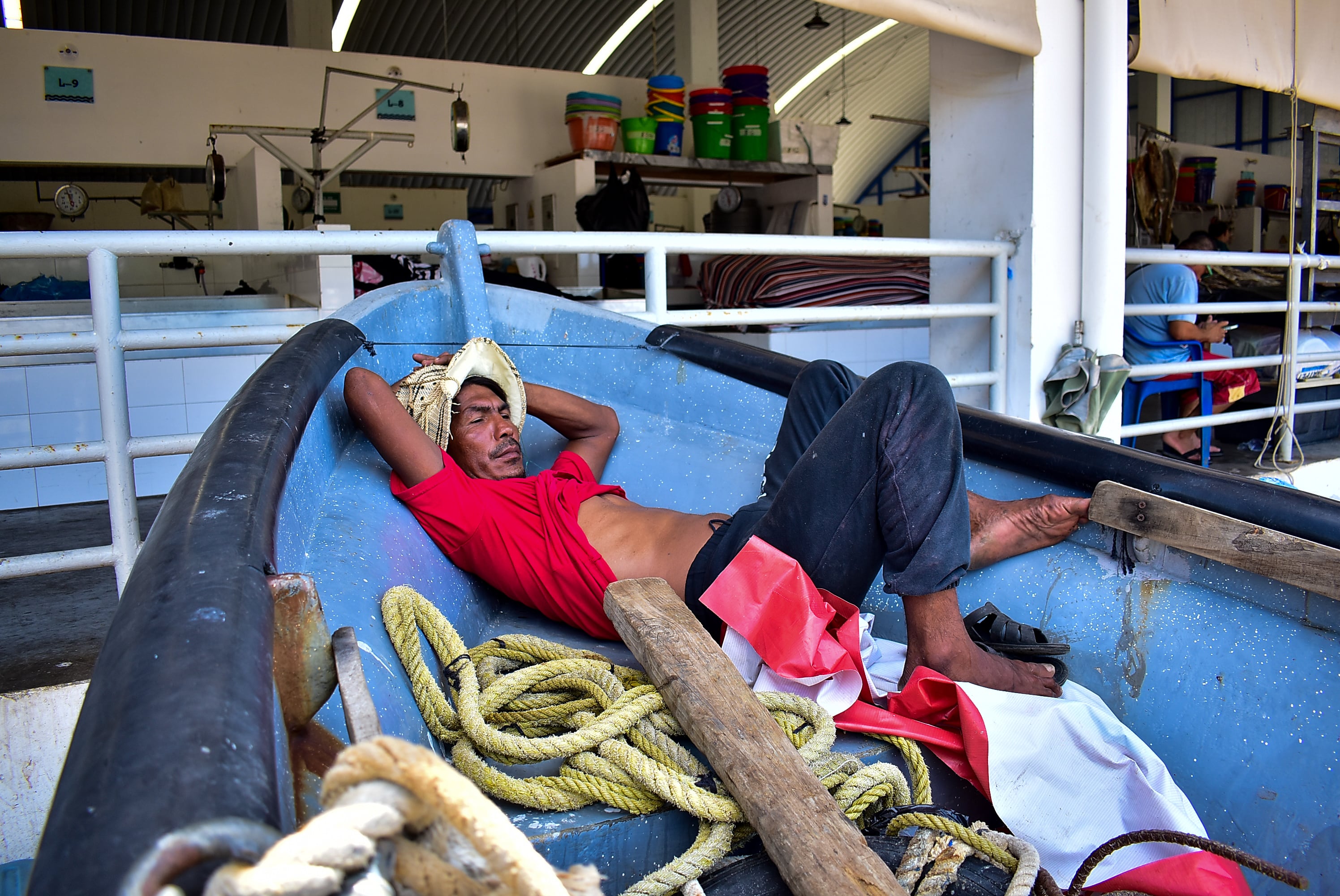 Un pescador descansa durante el medio día posterior a su jornada en el mar. (Infobae Centroamérica/Emerson Del Cid)