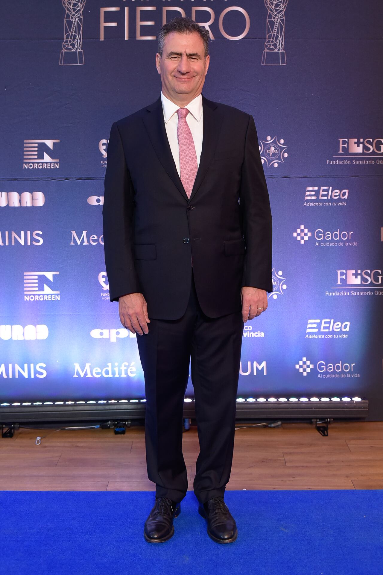 Regazzoni calzó zapatos negros de piel con acabado brillante y suela clara. No mostró accesorios visibles como reloj, pañuelo o insignias