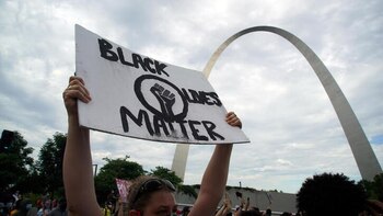 Una manifestante levanta un cartel