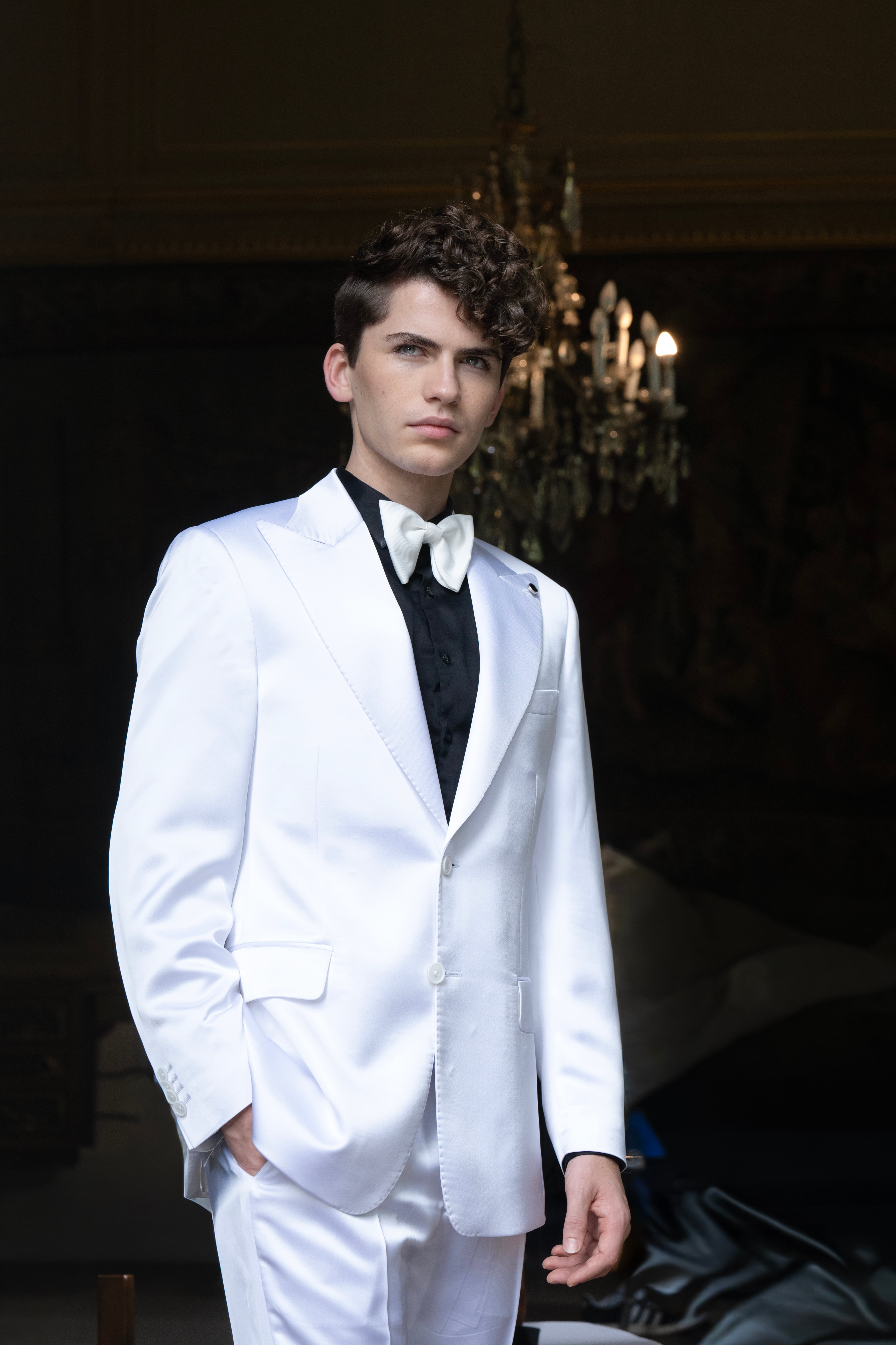 El cantante Martín Savi posa elegantemente con un traje blanco, camisa negra y pajarita, durante una sesión de prensa. (Federico de Bartolo)