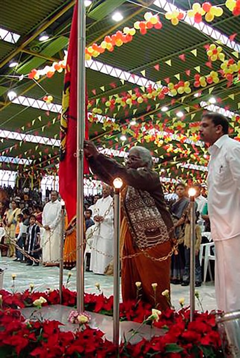 La madre de un combatiente tamil caído iza la bandera de Tamil Eelam durante la conmemoración de Maaveerar Naal en 2002, en Alemania