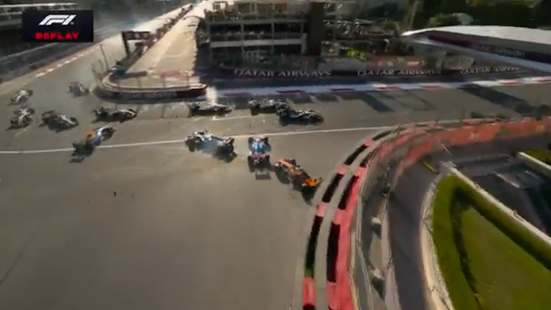 Un grupo de monoplazas de Fórmula 1 sufre una colisión múltiple en la curva de un circuito de carreras.