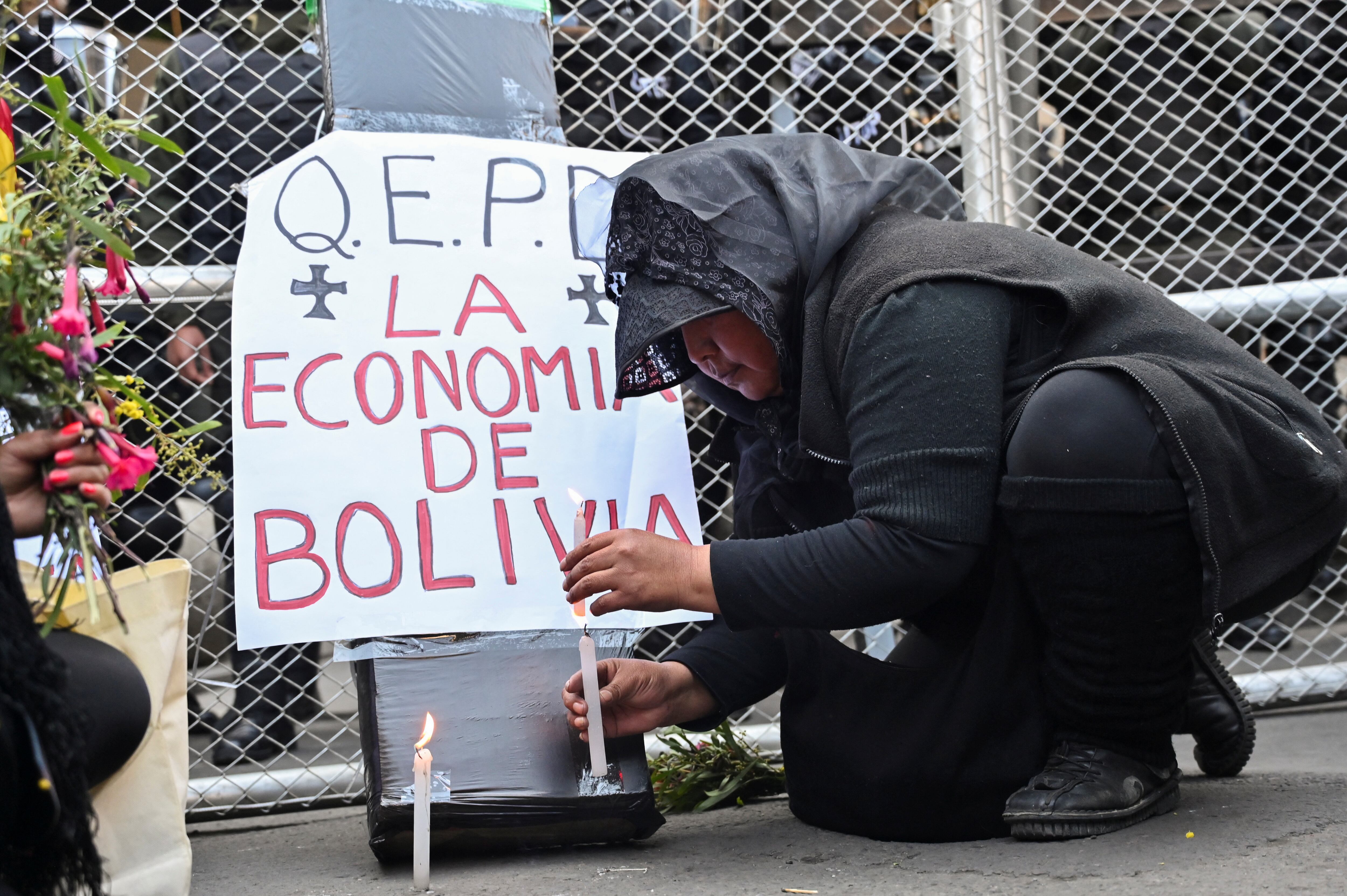 Una mujer se viste de luto y prende velas en representación por la