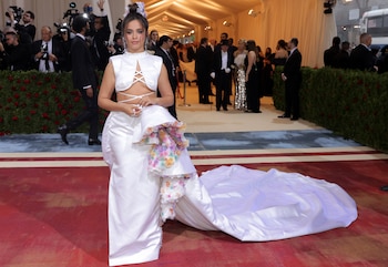 El vestido blanco satinado con aplicaciones florales y moño alto decorado fue la elección romántica de la artista para la Met Gala 2022 (REUTERS/Andrew Kelly)