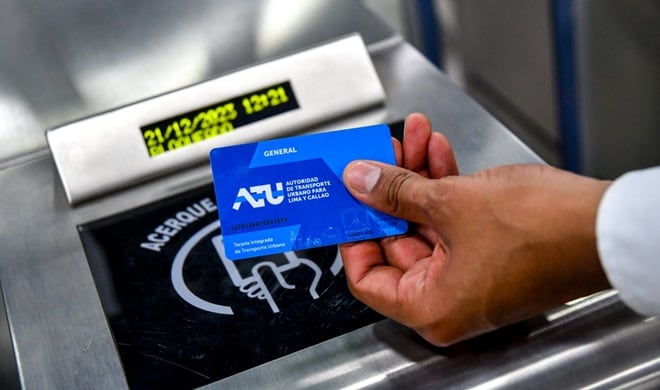 Un usuario acerca la tarjeta de la Autoridad de Transporte Urbano de Lima y Callao a un lector que muestra el estado
