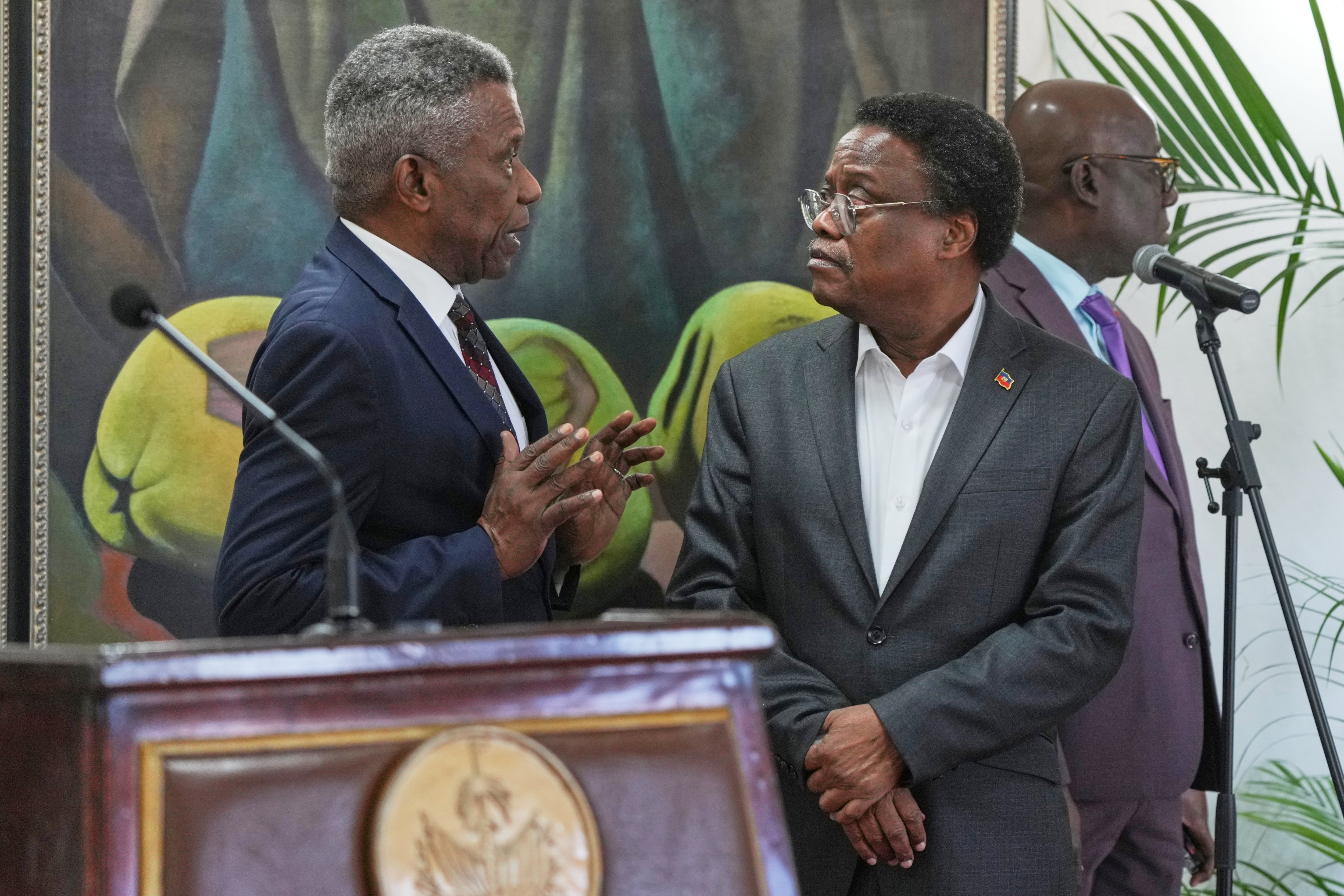 El jefe de protocolo del Palacio Nacional Marc Marie Yves Mazile habla con Fritz Alphonse Jean, miembro del consejo presidencial transicional de Haití, en Puerto Príncipe, el 25 de noviembre del 2025. (AP foto/Odelyn Joseph)