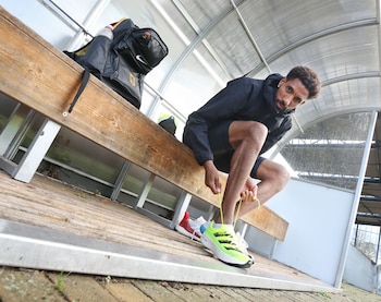 ARCHIVO - El maratonista alemán Amanal Petros se calza las zapatillas para un entrenamiento. Desde que se crearon calzados deportivos que llevan una placa de carbono, las marcas de los mejores varían constantemente. Foto: Roland Weihrauch/dpa