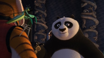 Un oso panda mira a una mantis religiosa situada sobre la espalda de una tigresa en un salón con columnas decoradas