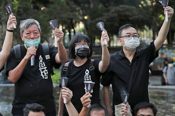 De izquierda a derecha, los activistas prodemocracia Lee Cheuk-yan, Chow Hang-tung y Cheung Man-kwong asisten a un acto para recordar a los fallecidos en la represión de Tiananmen de 1989, en el Parque Victoria, en Hong Kong, el 4 de junio de 2020 (AP/Kin Cheung)