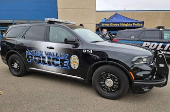 Un vehículo policial de color negro con la leyenda Apple Valley Police en el costado, estacionado al aire libre