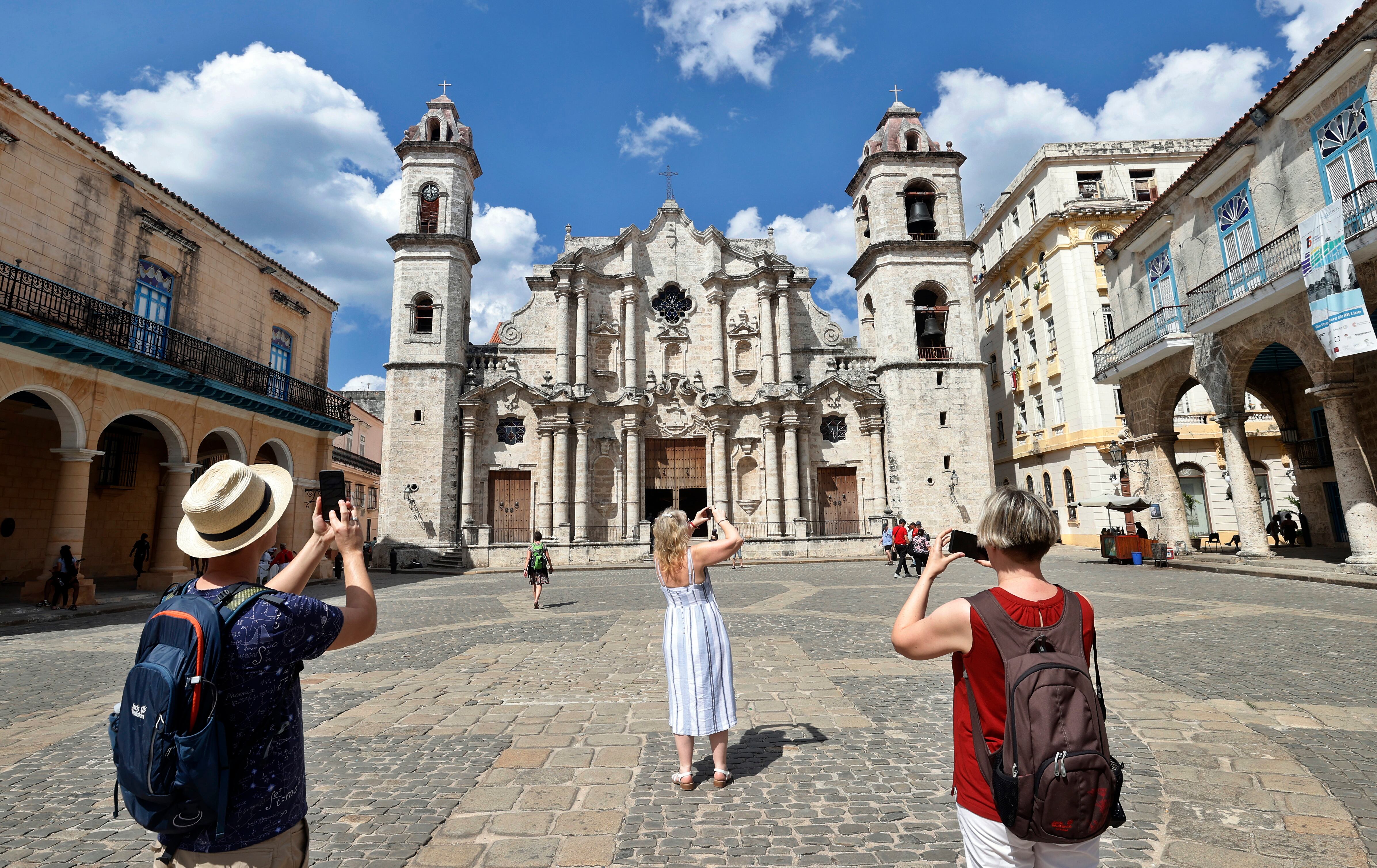 Un grupo de turistas toman fotos frente a la catedral de La Habana (EFE/Ernesto Mastrascusa/Archivo)
