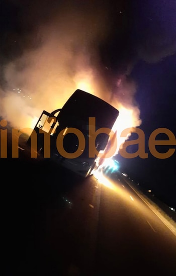 Vehículo en llamas sobre una ruta oscura de noche, con humo y chispas. El logotipo de Infobae aparece en naranja en la parte inferior