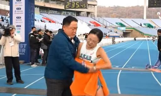 Kim Wan-gi sostiene a la atleta coreana tras la maratón (Captura de video)