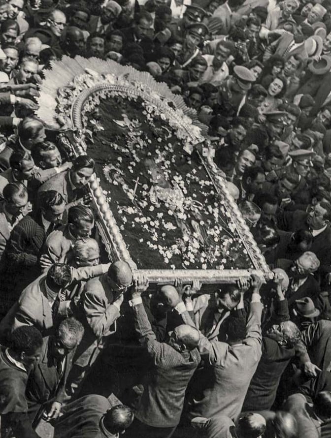 Una multitud de fieles acompaña y eleva en hombros la réplica de la imagen del Señor de los Milagros, antes de la construcción de su anda, durante un recorrido procesional en Lima. (Biblioteca Nacional del Perú)