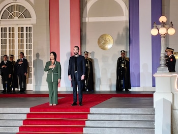 Keiko Fujimori y Nayib Bukele de pie sobre una alfombra roja frente a guardias de honor y banderas de Perú y El Salvador