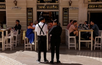 Dos trabajadores del sector servicios frente a un bar. (REUTERS/Jon Nazca)