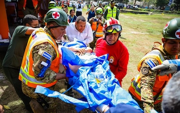 Integrantes del contingente salvadoreño trasladan a una persona rescatada con vida tras los terremotos en Venezuela, durante las operaciones de auxilio en la zona de desastre (Cortesía Secretaría de Prensa).