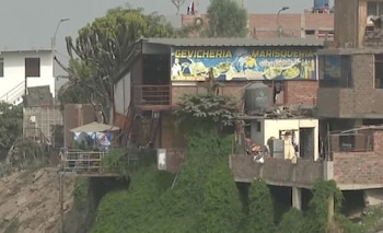 Inmueble con letrero de cevichería y marisquería edificado sobre una ladera de tierra con vegetación
