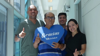 Paciente Saturnino Bazán Quinto con tres miembros del personal médico, todos sonriendo y dando pulgares arriba, sosteniendo un cartel azul en forma de corazón con 'Gracias EsSalud'