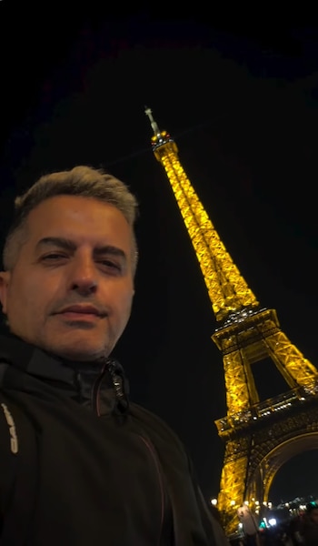 Ángel de Brito se fotografió junto a la Torre Eiffel iluminada durante la noche