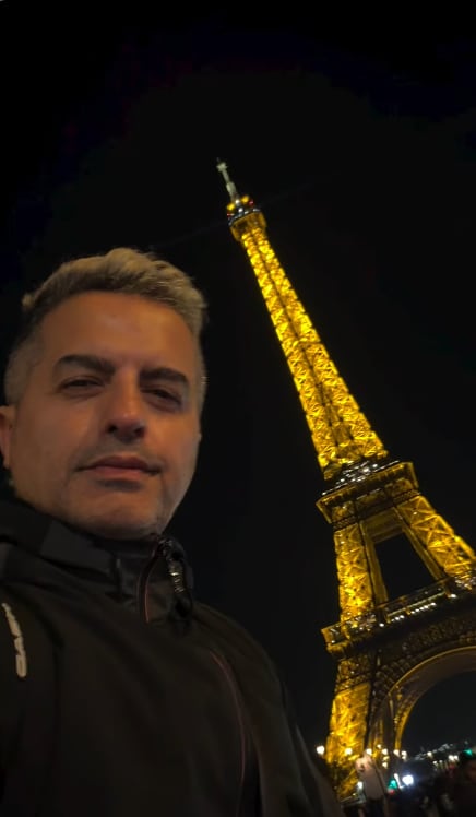 Ángel de Brito se fotografió junto a la Torre Eiffel iluminada durante la noche