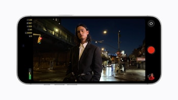 Un teléfono horizontal muestra en su pantalla a una persona en una calle de noche junto con botones digitales de grabación