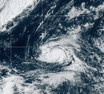 Masa de nubes blancas arremolinadas en forma de espiral sobre el agua oscura del océano con líneas finas de cuadrícula superpuestas