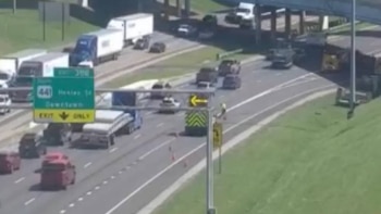 Imagen aérea de una autopista con múltiples carriles y tráfico denso de coches y camiones, con señales de salida visibles para Henley Street y Downtown